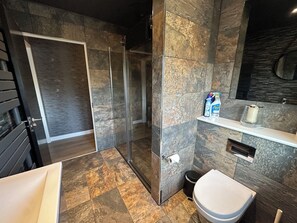 A modern bathroom with a shower, toilet, and sink. - The Tay (Melrose)