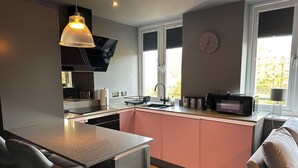 Uma cozinha moderna com uma ilha central, forno embutido e janela com vista.