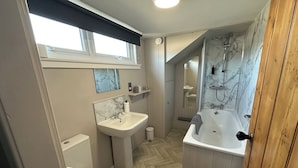 A modern bathroom with a sink, toilet, shower, and bathtub. - The Tweed (Melrose)