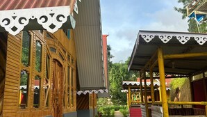A wooden building with a corrugated metal roof, a covered porch, and a garden pathway. - Ganganiwas Homestay Sonada (Darjeeling)
