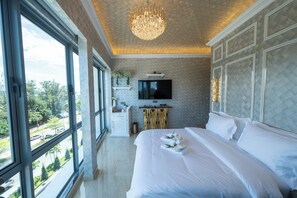 A hotel room with a large bed, a TV, a wooden cabinet, and a view of the outside. - Regis by Ritz Imago Mall Loft B (Kota Kinabalu)