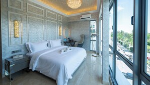 Un hotel moderno con una cama grande, un candelabro, vistas a la ciudad y un balcón.
