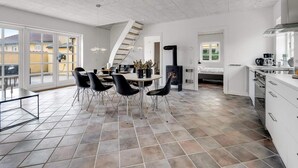 Una cocina amplia con zona de comedor, estufa integrada y un ventanal grande.