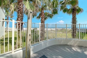 A covered outdoor area with a white railing, palm trees, and a view of the beach. - Admirals Quarters 708 | Beachfront Views | Luxury Amenities | Heart of Orange Beach (Orange Beach)