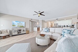 Ein modernes Wohnzimmer mit Sofa, Couchtisch und Fernseher.