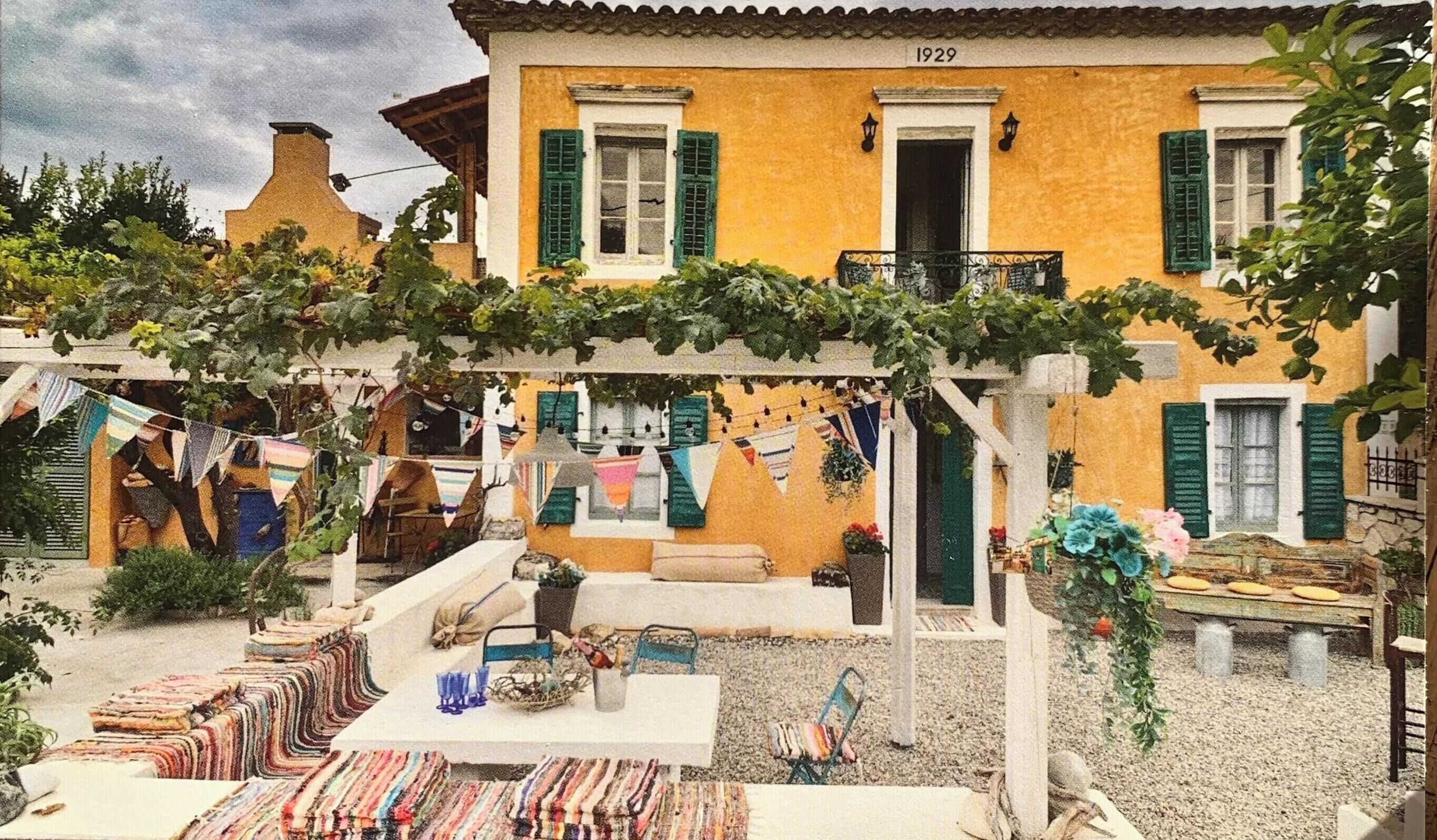 A building with a balcony, a table with chairs, and a hanging clothesline.