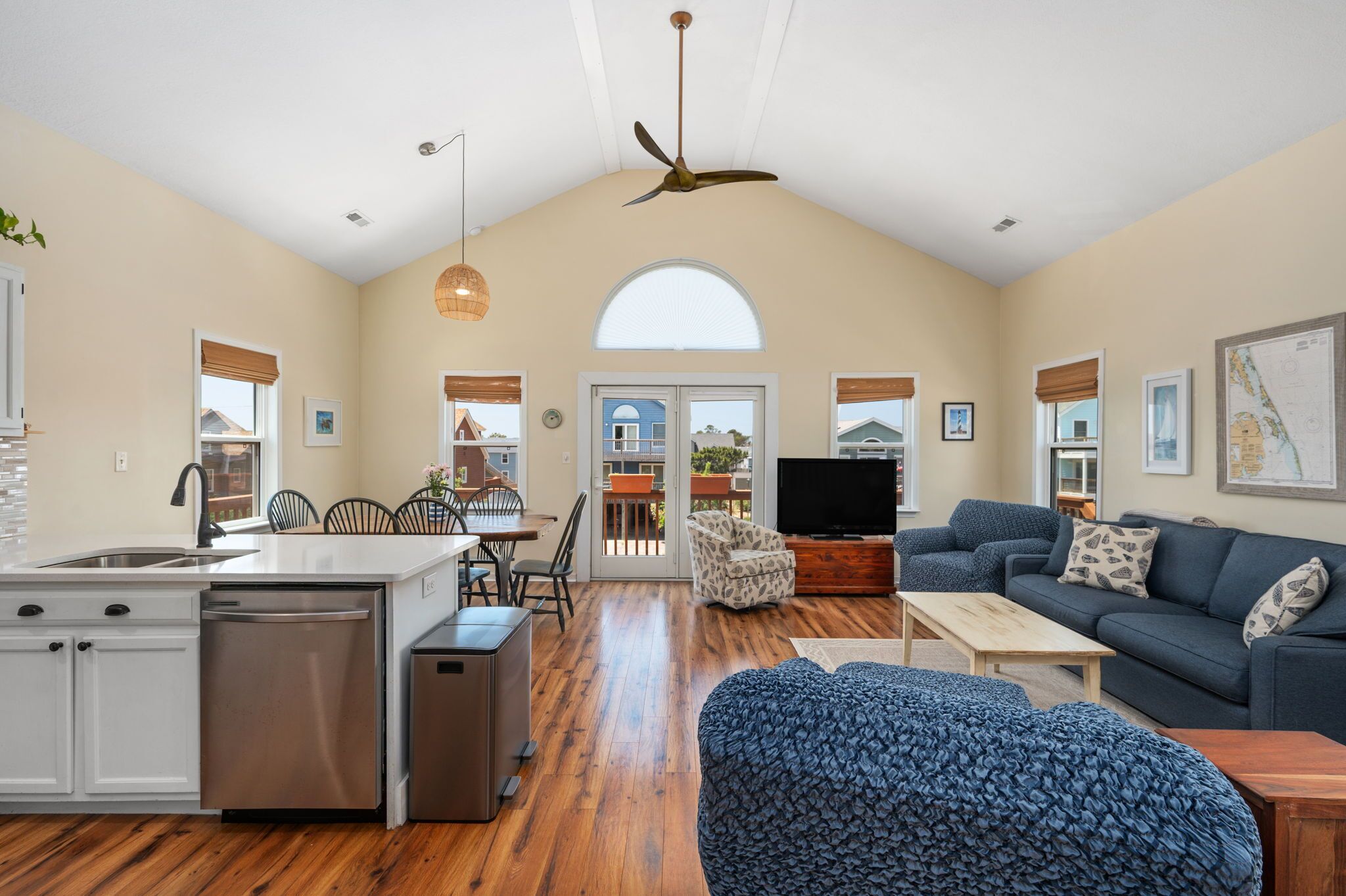 A spacious living area with a kitchen, dining table, and seating area.