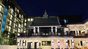 Ein mehrstöckiges Hotel mit einer markanten Eingangshalle, einem überdachten Balkon und einem Innenhof.