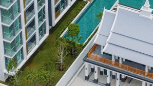 Ein modernes Hotel mit Schwimmbad, mehreren Balkonen und traditioneller Architektur.