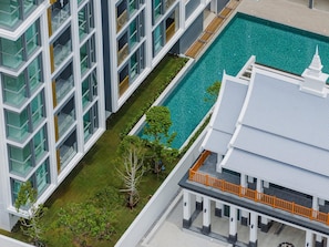 A modern hotel with a swimming pool, multiple balconies, and a traditional architectural style. - Bangtao Laguna Apartment 42 sq.m in picturesque Phuket. (Choeng Thale/Thalang)