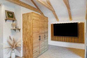 A room with a wooden wardrobe, a mounted TV, and decorative items on the wall. - Holiday Apartment "Benedetti" with Balcony, Mountain View and Wi-Fi (Mittenwald)
