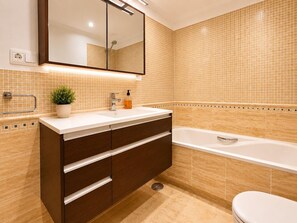 A bathroom with a double sink vanity, a bathtub, and a toilet. - House near the calm family beach (Estepona)