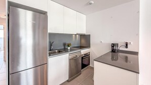 A compact kitchen with a stainless steel refrigerator, a dishwasher, and a coffee maker. - Bright apartment, sea view - 4 guests (Estepona)