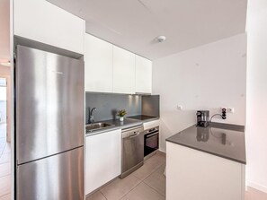 A compact kitchen with a stainless steel refrigerator, a dishwasher, and a coffee maker. - Bright apartment, sea view - 4 guests (Estepona)