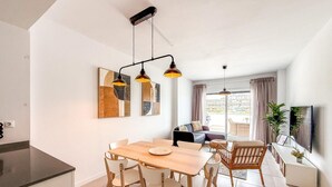 A modern kitchen with a dining area, a sofa, and a TV. - Bright apartment, sea view - 4 guests (Estepona)