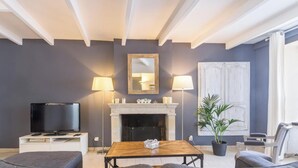 A living room with a TV, fireplace, and seating area.