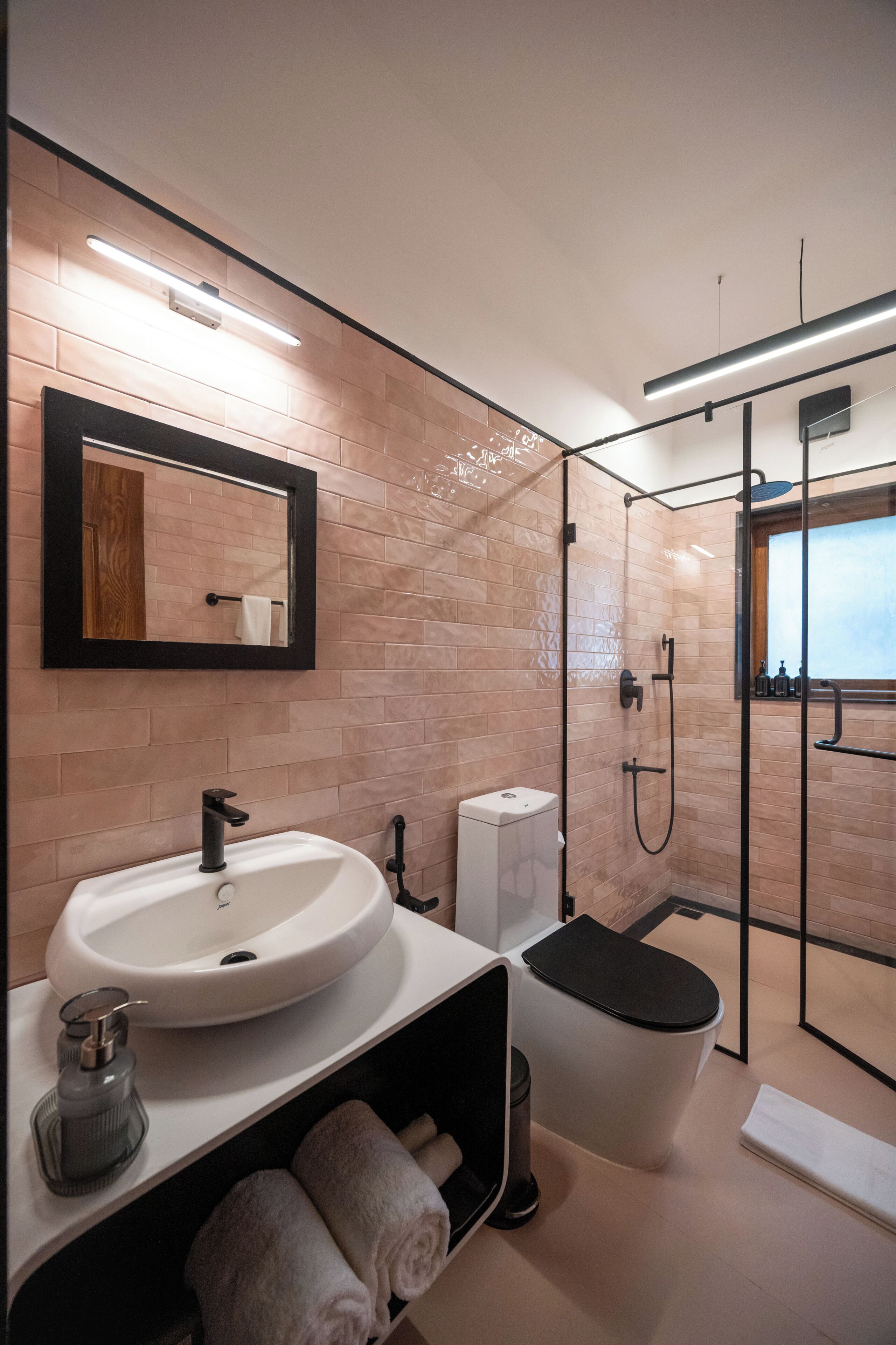 Un baño moderno con un lavamanos grande, un espejo, un inodoro y un box de ducha.