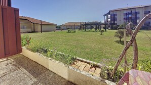Un patio con edificios, una pérgola y cielo despejado.