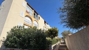 A narrow street with a building featuring balconies and a wrought iron fence. - Cozy apartment with balcony - 4 guests (Narbonne)