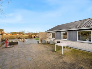 A residential backyard with a patio, outdoor seating, and a red fire hydrant. - 4 Star Holiday Home in Lokken (Lokken)