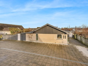 A residential property with a paved driveway, a detached garage, and a brick house. - 4 Star Holiday Home in Lokken (Lokken)
