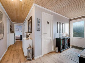 A hallway with wooden flooring, a white door, a bookshelf, and a window with frosted glass. - 4 Star Holiday Home in Lokken (Lokken)