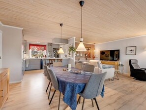 A modern living space with a dining area, kitchen, and seating area. - 4 Star Holiday Home in Lokken (Lokken)