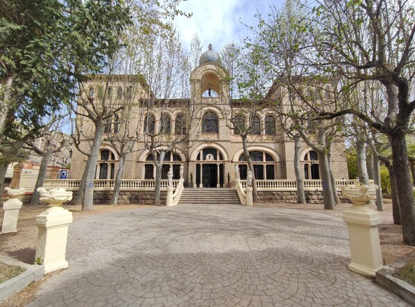 A historic building with a central dome, arched windows, and a symmetrical facade.