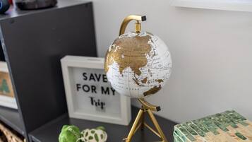 A globe on a tripod stand, a framed sign with text, and a green gift box.