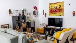 A living room with a sofa, armchairs, a TV, and a bookshelf with various decorative items. - 'Casa Da Viajante' with Private Pool, Wi-Fi and Air Conditioning (Fronteira)