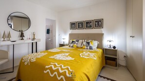 A bedroom with a bed, bedside table, lamp, and wall-mounted pictures. - 'Casa Da Viajante' with Private Pool, Wi-Fi and Air Conditioning (Fronteira)