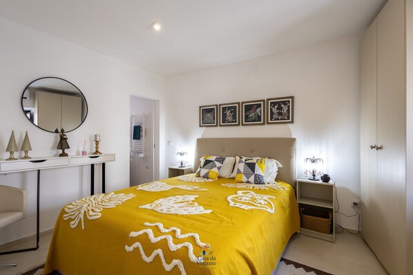 Ein Schlafzimmer mit Bett, Nachttisch, Lampe und Bildern an der Wand.