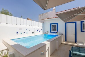 Ein Schwimmbecken mit weißer Wand, blauer Umrandung und dekorativen Schmetterlingstiles.