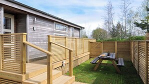 A wooden deck with a picnic table and a staircase leading to a building. - 3 Faraway Fields (Liskeard)
