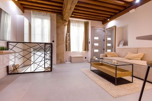 A modern living room with a sofa, coffee table, and a decorative metal partition. - Le Caveau Dijonnais – Exceptional Duplex (Dijon)