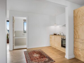 Eine moderne Küche mit Holzausstattung, einem Einbauofen und einer kleinen Arbeitsfläche.