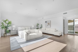 A modern living room with a sofa, a coffee table, and two potted plants. - Laurel Ridge: Elevated Canyon Escape With Spa-like Living & Style (Los Angeles)