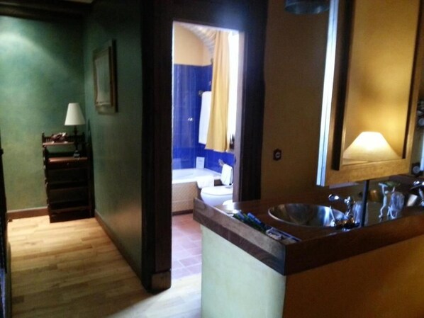 Un baño con lavamanos, espejo y barra para toallas.