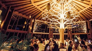 Un grand hall ouvert avec un haut plafond en bois et un luminaire central en forme d’arbre.