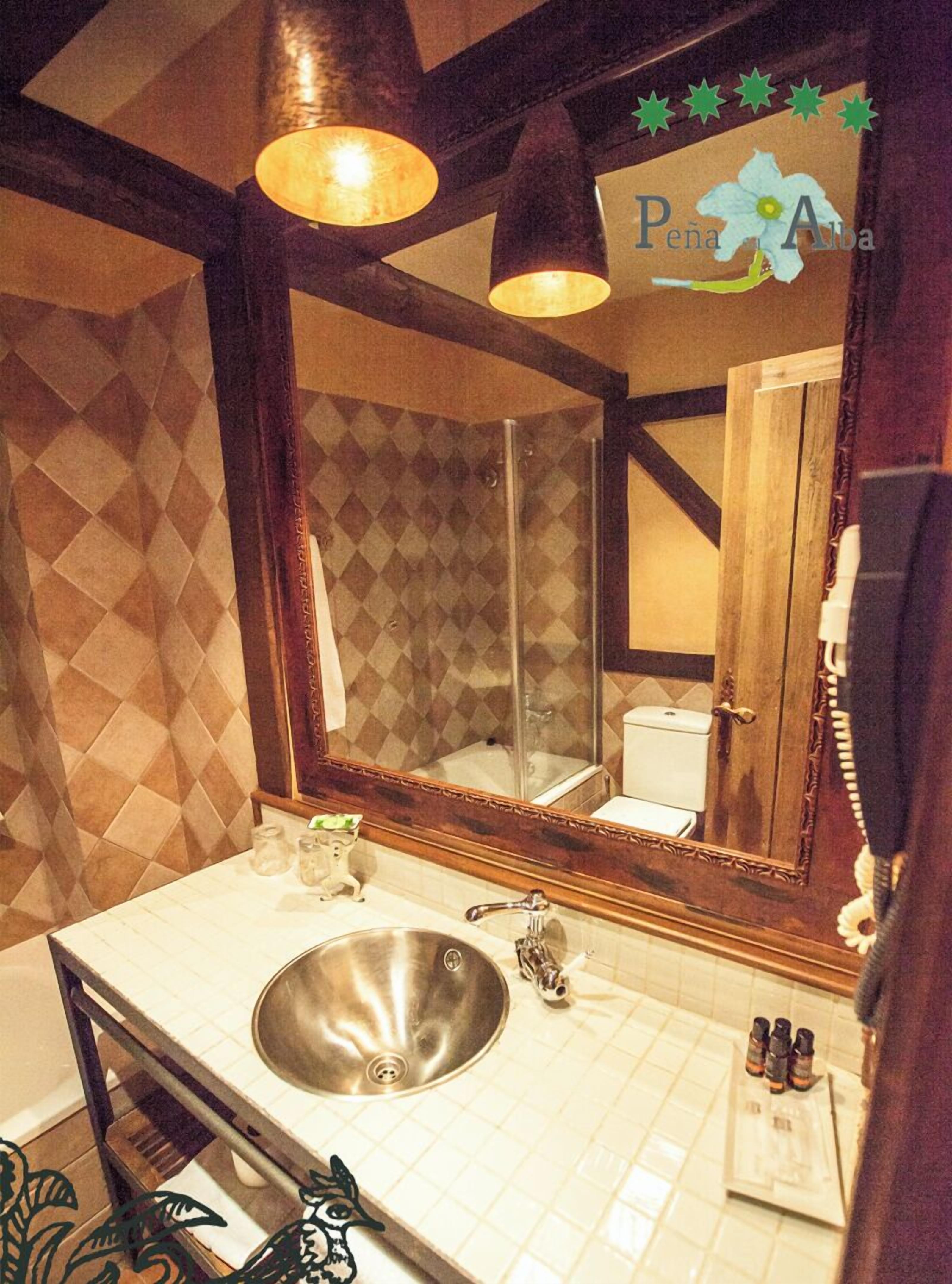 A bathroom with a large mirror, a sink, and a shower.