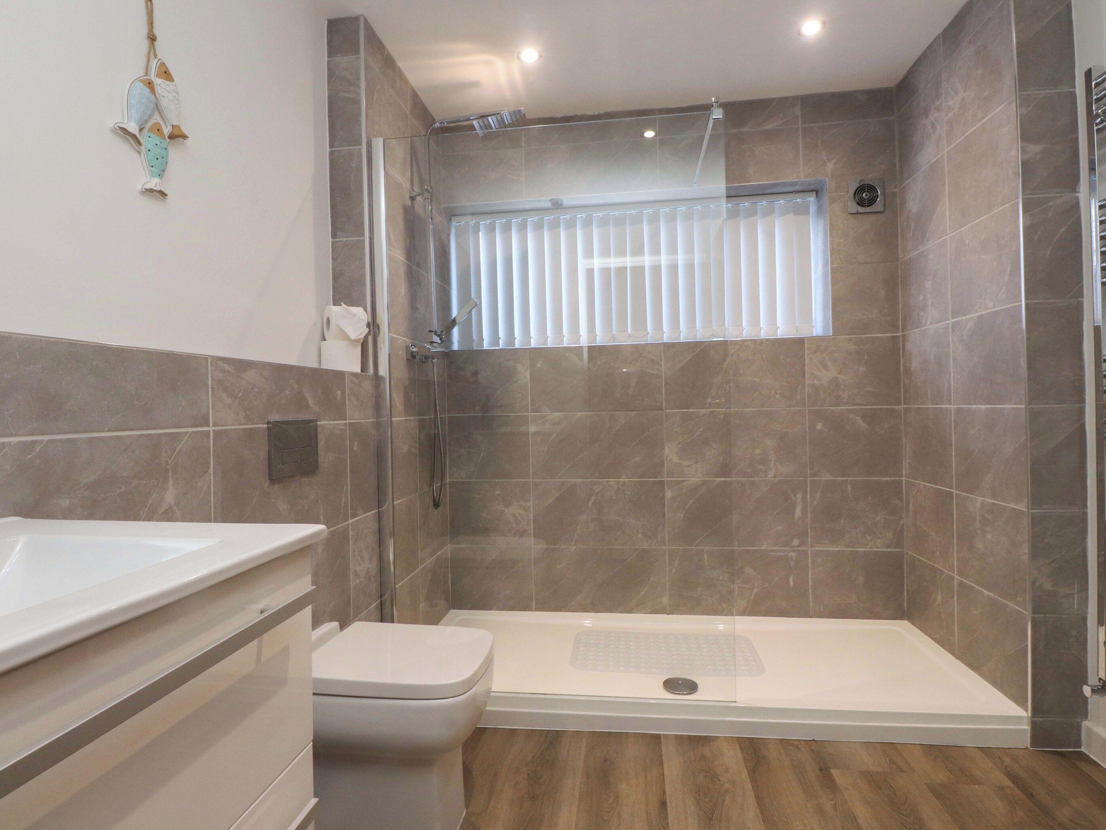 A modern bathroom with a shower, toilet, and vanity.