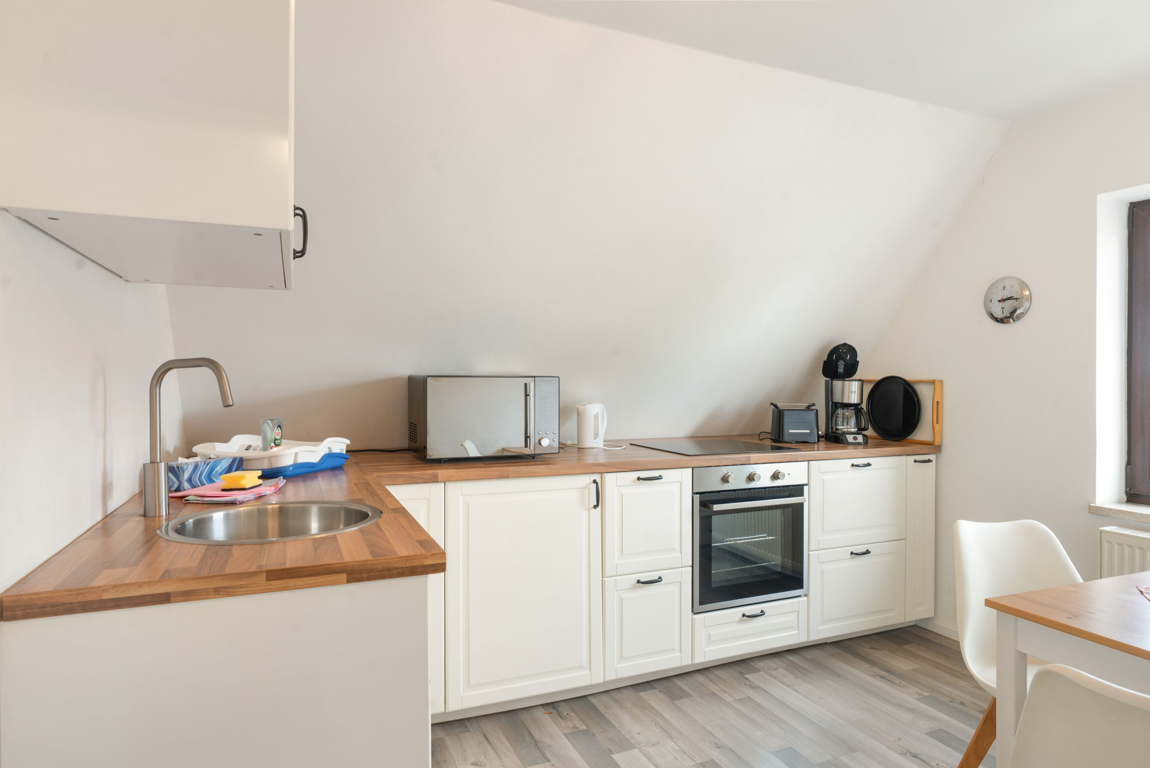 A compact kitchen with a sink, microwave, toaster, and oven.