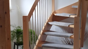 A staircase with wooden handrails and grey carpeted steps. - Apartment 'Fewo Drei Gleichen Nr 1' with Wi-Fi (Drei Gleichen)