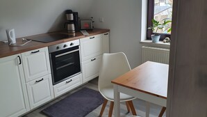 A kitchen with a built-in oven, a coffee maker, a toaster, and a window with a view of the outside.