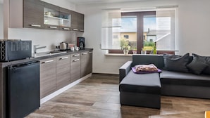 Una cocina moderna con armarios de madera oscura, un refrigerador negro y una cafetera.