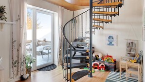 A modern interior with a spiral staircase, a dining area, and a children's play area. - 4 Star Holiday Home in Lokken (Lokken)