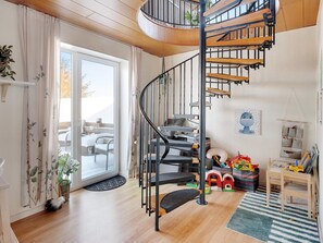 A modern interior with a spiral staircase, a dining area, and a children's play area. - 4 Star Holiday Home in Lokken (Lokken)