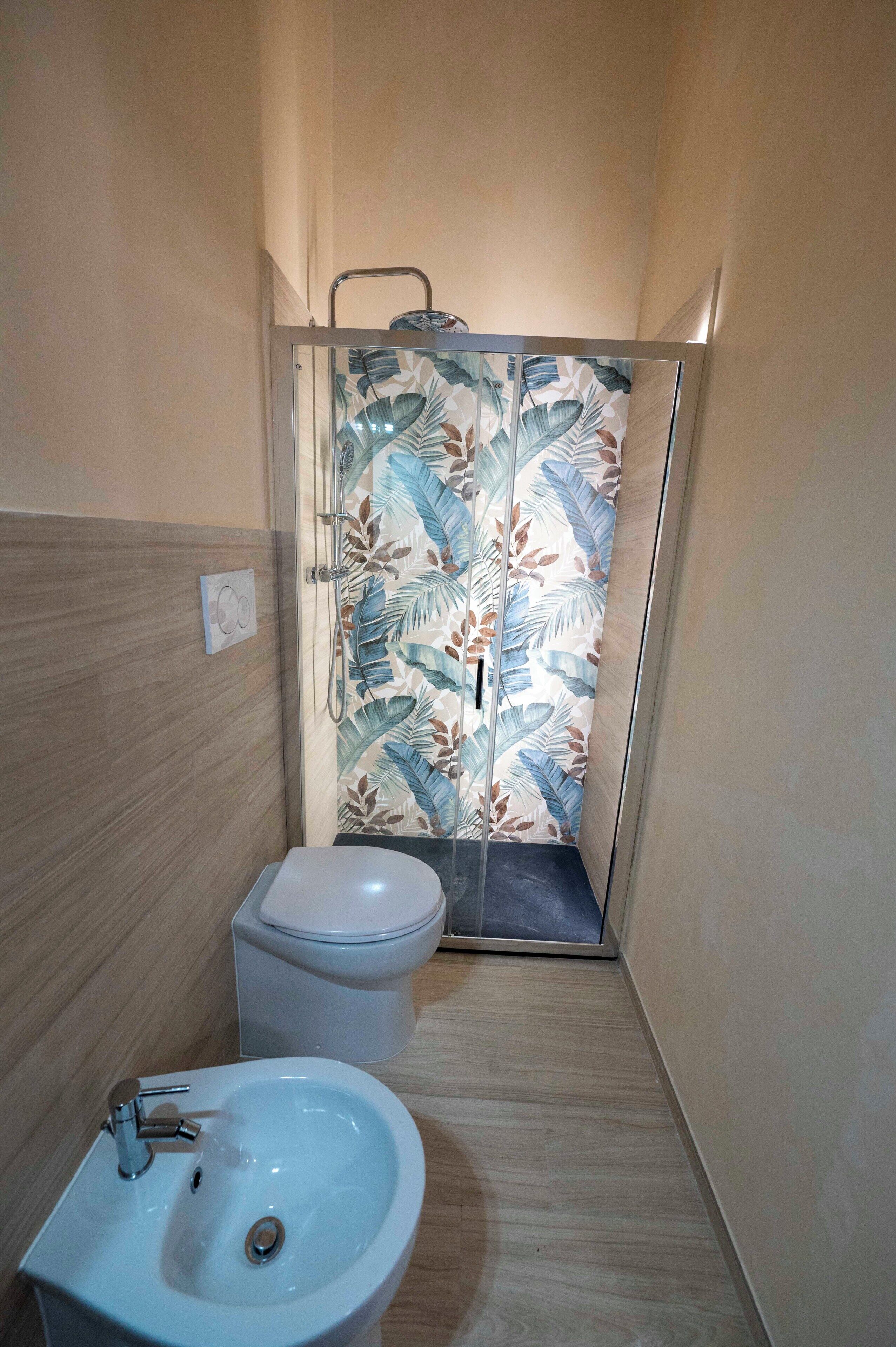 A bathroom with a shower, toilet, and sink.