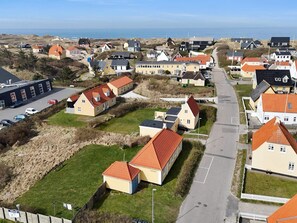 Ein Küstendorf mit Häusern, einer Straße und einem Strand im Hintergrund.