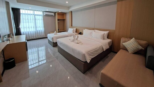 A hotel room with two beds, a desk, a wardrobe, and a bathroom. - Room-velin Pattaya Hotel-family 1 (Pattaya)